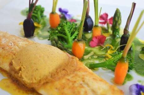 Lubina con mantequilla de especias, jardín de verduras y licuado de espinacas.