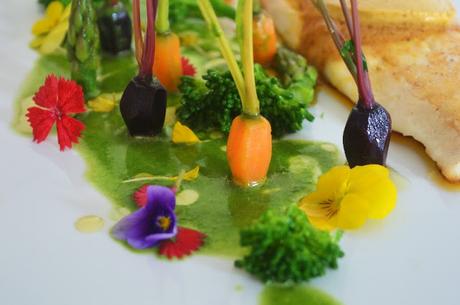 Lubina con mantequilla de especias, jardín de verduras y licuado de espinacas.