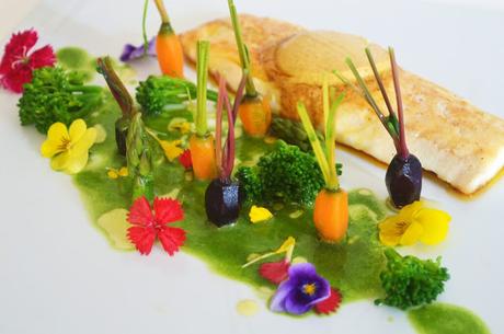 Lubina con mantequilla de especias, jardín de verduras y licuado de espinacas.