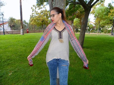 Maxi jersey asimétrico con vaqueros rasgados, botines burdeos, maxi bufanda y reloj