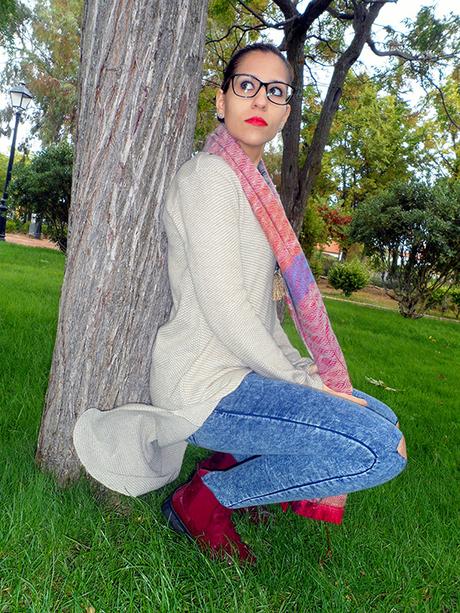 Maxi jersey asimétrico con vaqueros rasgados, botines burdeos, maxi bufanda y reloj