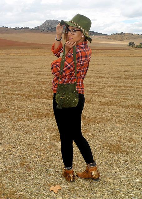 Camisa de cuadros con vaqueros rotos, botas boho, sombrero y bolso