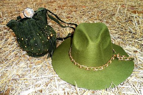 Bolso verde con tachuelas, sombrero verde con cadena y reloj marrón envejecido