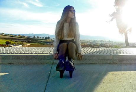 Falda denim acamapanda, jersey de punto rasgado, cazadora biker negra y botines de tacón con hebillas