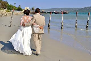 Pareja de novios paseando por la playa