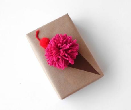 Envoltorio de regalo con papel kraft y helado con pompón de lana