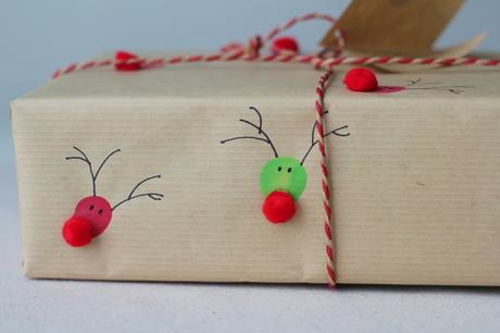 Envoltorio para regalo hecho con papel craft y huellas digitales con forma de reno