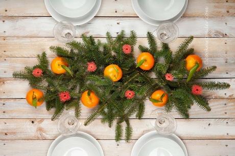 Centro de mesa DIY para Navidad hecho con ramas de abeto y mandarinas