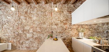 revestimiento de piedra y madera Reformas Barcelona pisos diáfanos estilo nórdico espejo bajo los armarios superiores distribución diáfana cocina abierta moderna blog decoración nórdica 