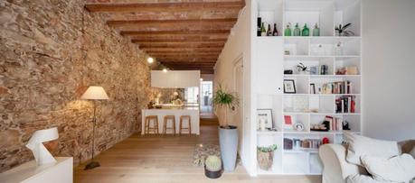 revestimiento de piedra y madera Reformas Barcelona pisos diáfanos estilo nórdico espejo bajo los armarios superiores distribución diáfana cocina abierta moderna blog decoración nórdica 