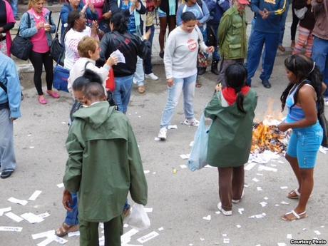 1- Las turbas que integran las Brigadas de Respuesta Rápida (BRR) queman volantes y ejemplares de la Declaración Universal de los Derechos Humanos que les lanzaron las Damas de Blanco en su sede de Lawton, La Habana. Foto cortesía Ángel Moya.