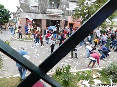 5- Miembros de las BRR recogen los volantes y ejemplares de la Declaración Universal de los Derechos Humanos que lanzaron hacia la calle las Damas de Blanco. Foto cortesía Ángel Moya.