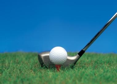 close-up of a golf ball on a tee and a golf club next to it