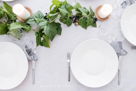 Mesa decorada con ramas de grosellas e higos