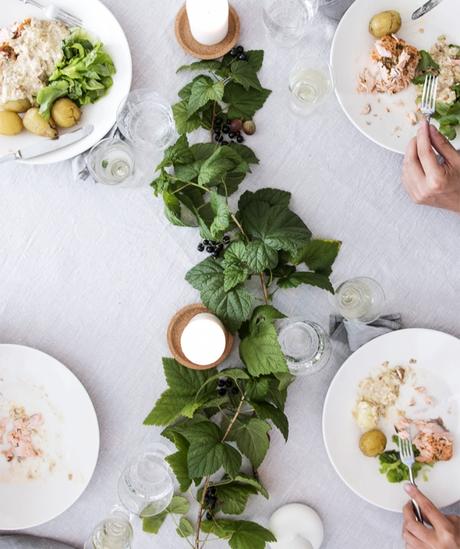 Mesa decorada con ramas de grosellas e higos