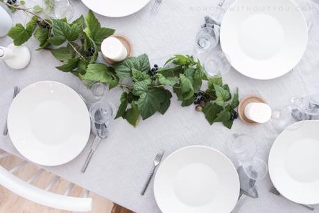 Mesa decorada con ramas de grosellas e higos