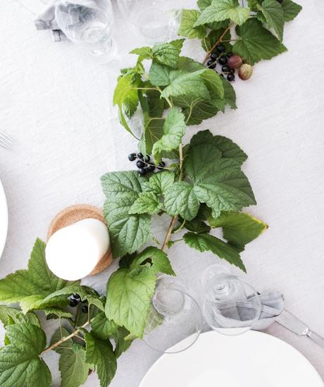 Mesa decorada con ramas de grosellas e higos