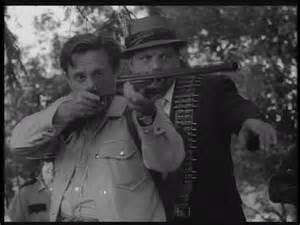 Fotograma en el que se ve a uno de los hombres del comisario McClellan disparando contra Ben, asomado a una de las ventanas de la casa 