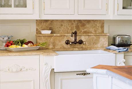 In this French country kitchen, designer Beverly Ellsley chose cedar limestone for the countertops and backsplash, which has a convenient shelf for soap. 