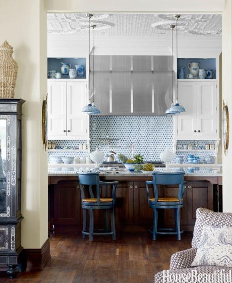 The kitchen backsplash, from Urban Archaeology, is beautiful and practical, and open shelves for display break up the cabinetry in this Lake Michigan home's kitchen. Designer Martin Horner chose blue mercury-glass pendants from Gallery L7 to pick up the color theme and the home's exotic style.  