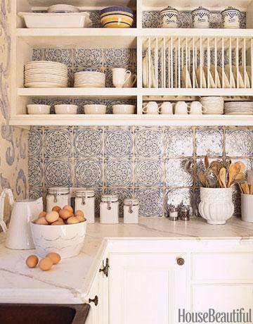 Above the countertops and stove of this California kitchen by designer Erin Martin, the backsplash is clad in a romantic blue-and-white French tile from Country Floors. 