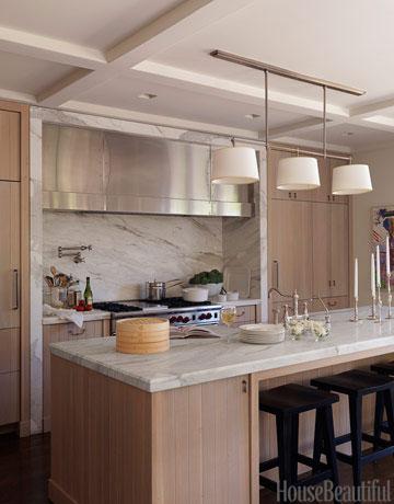 In this modern Los Angeles kitchen, architect William Hefner balanced the oak wood with a Calacatta gold marble backsplash and a matching island. 