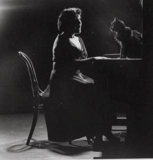 Blackie, Gjon Mili's cat, sitting on piano as Jennie Tourel, French opera star, sings.