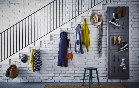 Ganchos para colgar abrigos y chaquetas en la pared de debajo de la escalera. Frente de puerta colgado en la pared, con ganchos para los zapatos.