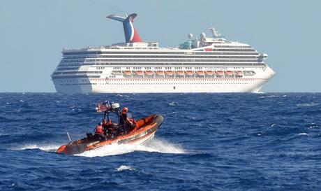 A small boat from the U.S. Coast Guard Cutter Vigorous patrols near the cruise ship Carnival Triumph in the Gulf of Mexico, in this February 11, 2013 handout photo. The cruise ship lost propulsion after an engine room fire on February 10 and was adrift off southern Mexico's Yucatan peninsula. REUTERS/U.S. Coast Guard/Lt. Cmdr. Paul McConnell/Handout (GULF OF MEXICO - Tags: MILITARY SOCIETY MARITIME TRANSPORT TRAVEL) FOR EDITORIAL USE ONLY. NOT FOR SALE FOR MARKETING OR ADVERTISING CAMPAIGNS. THIS IMAGE HAS BEEN SUPPLIED BY A THIRD PARTY AND WAS PROCESSED BY REUTERS TO ENHANCE QUALITY. AN UNPROCESSED VERSION WAS PROVIDED SEPARATELY