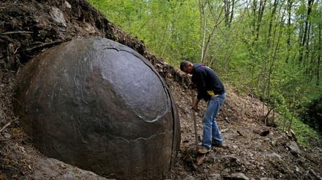 Suad Keserovic cleans a stone ball in Podubravlje village near Zavidovici, Bosnia and Herzegovina April 11, 2016. Keserovic claimed that the stone sphere is 3.30 meter in diameter and the estimated weight of it is about 35 tons.  (REUTERS/Dado Ruvic)