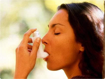 mujer usando inhalador para el asma