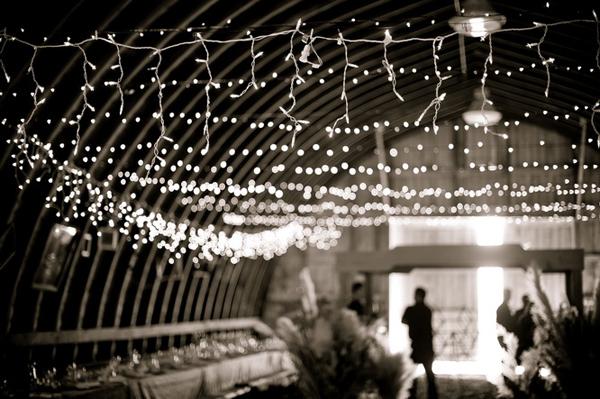 Banquete en un granero iluminado con guirnaldas de luces