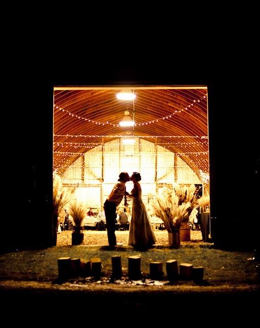 Banquete en un granero iluminado con guirnaldas de luces