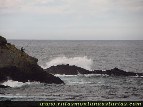 Pescador pescando en roca sobre el mar cantábrico