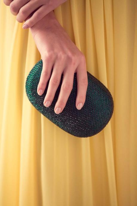 Los complementos de fiesta que desearás llevar este verano El clutch Mahonia en color verde va a la perfección con un vestido amarillo