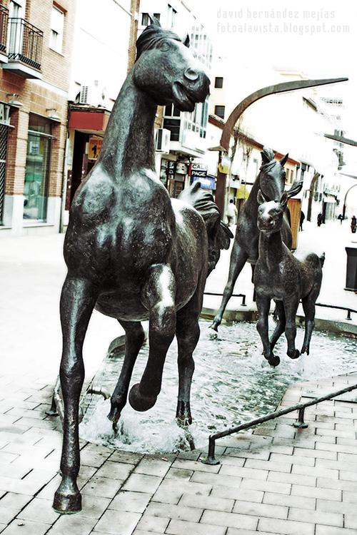 Conjunto escultórico urbano de caballos galopando sobre el agua y el asfalto, en Torrejón de Ardoz, Madrid