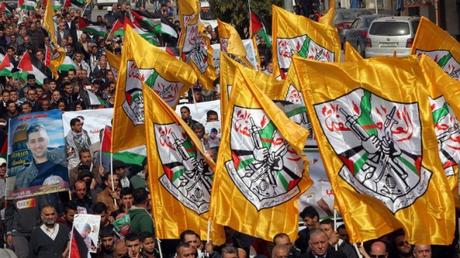 Palestinian demonstrators hold Fatah party flags as they demonstrate in the center of the West Bank city of Hebron on November 4, 2015. (AFP/HAZEM BADER)