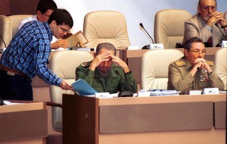 398898 03: Government official Carlos Valenciaga (L) delivers documents Cuban President Fidel Castro (2nd L) during a National Assembly meeting December 20, 2001 in Havana. The parliament passed a new anti-terroism law. At (R) is Raul Castro, the minister of the armed forces. (Photo by Jorge Rey/Getty Images)