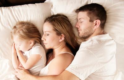 Padre madre e hija durmiendo juntos