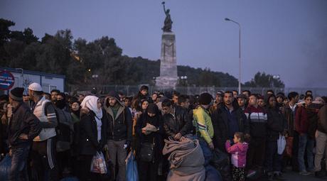 Refugiados aguardan el ferry a escasos metros de la estatua de la libertad del puerto de Mitilene, Lesbos / Foto: Olmo Calvo