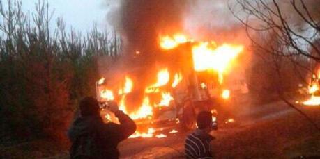 Vehñiculo ardiendo, con pirómanos o incendiarios observando