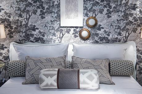 Cojines estampados sobre cama en tonos grises