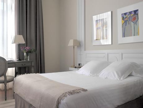 Cama vestida con funda, almohadas y cuadrantes blancos