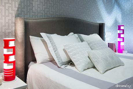 Cama con cabecero de tela y cuatro filas de cojines