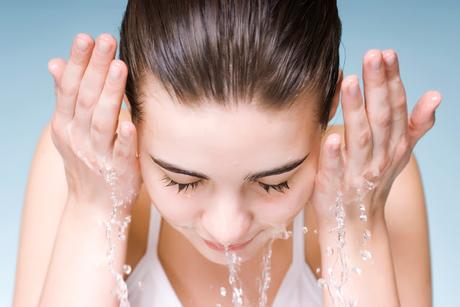 mujer lavándose la cara