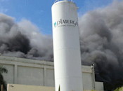 Fuego consume cartonera; camiones bomberos luchan llamas.