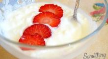 yogur con cachitos de fresas en un cuenco de vidrio junto a cuchara