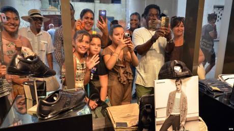 Cubanos asustados se retratan ante la vidrieras de tiendas de “lujo” en La Habana