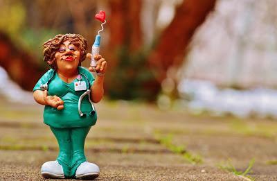 Imagen de una caricatura de una enfermera, en uniforme verde y jeringa con un corazón