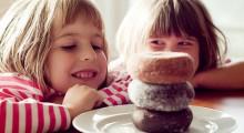 dos ninas mirando a los donuts con una sonrisa en la boca